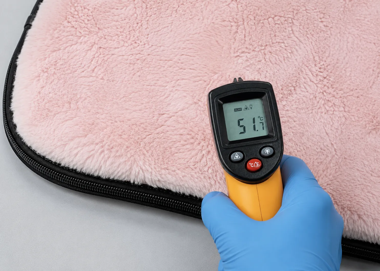Infrared temperature test on a pink pet warming mat during quality inspection