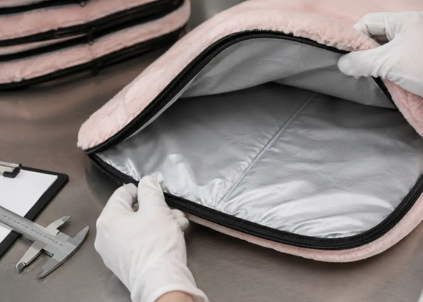 Final inspection of the zipper and internal lining of a pink pet warming mat