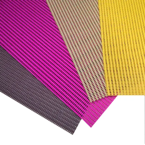 Non-slip mesh mats in purple, pink, beige and yellow showing their open-weave texture.