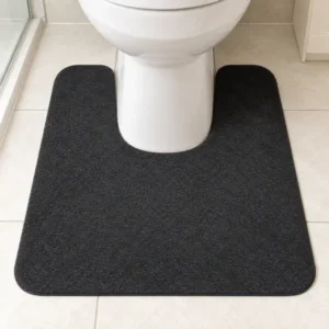 Black U-shaped toilet rug placed around the front of a toilet base on a tiled bathroom floor.