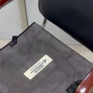 Caregiver assists a seated woman with backward repositioning using a one way slide seat cushion.